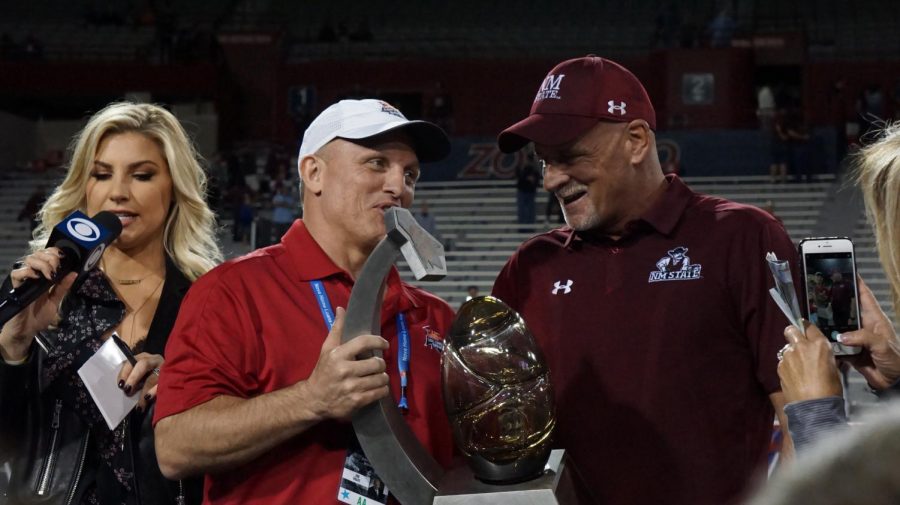 Coach Doug Martin accepting the Arizona Bowl trophy.