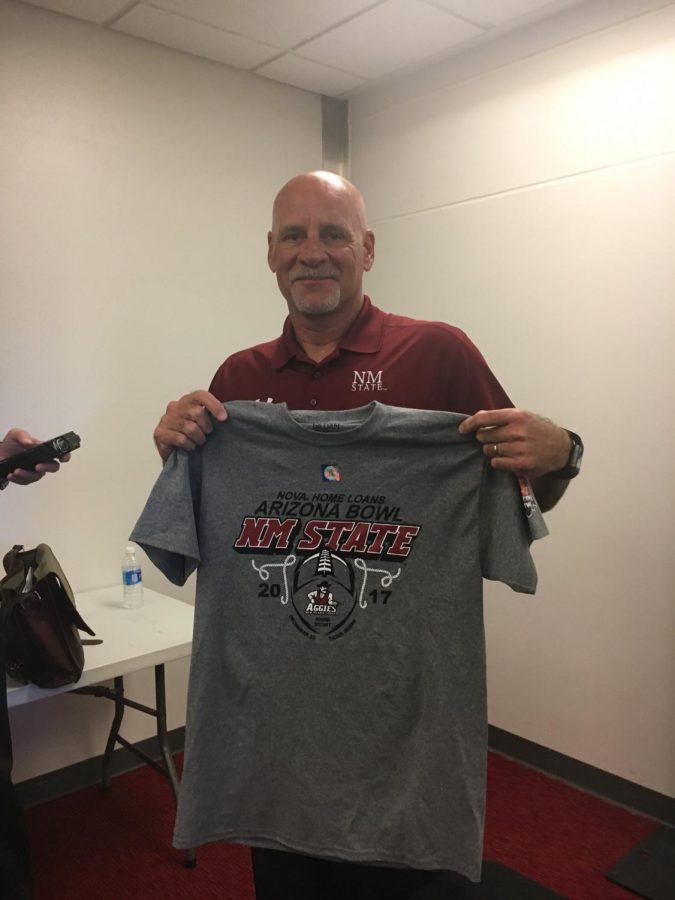 NMSU head coach Doug Martin takes picture with NOVA Home Loans Arizona Bowl t-shirt. The Aggies will be making their first bowl appearance since 1960.