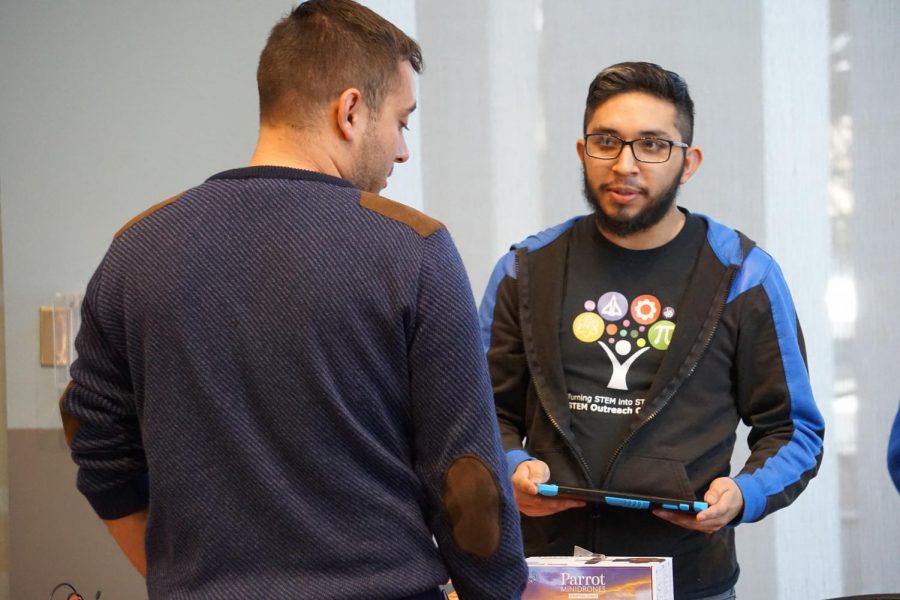 Senior mechanical engineer major, Mario Garcia, demonstrates drones to a student