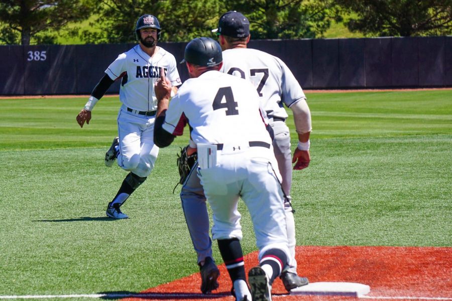 A NMSU base-runner gets ready to slide in to third base during Sundays series finale against Utah Valley.