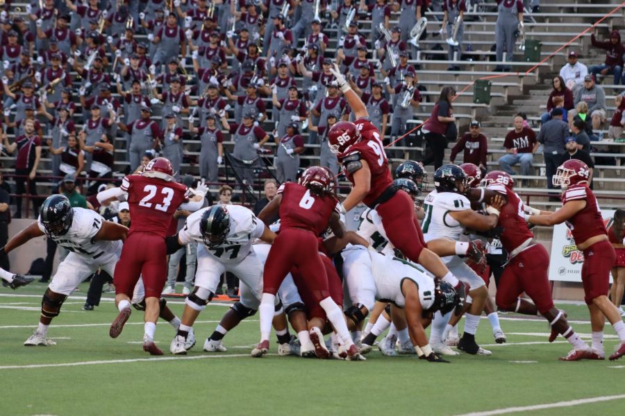 NMSU Defensive Linemen Garrett Bishop (#96) tackles University of Hawaii players.