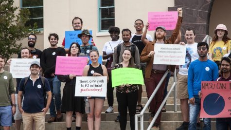 Graduate students and other supporters at the Graduate Worker Union rally hold signs while taking a group picture on June 9, 2022