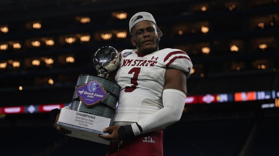 Chris Ojoh who led the team with seven tackles and a forced fumble  holding the Quick Lane Bowl trophy.