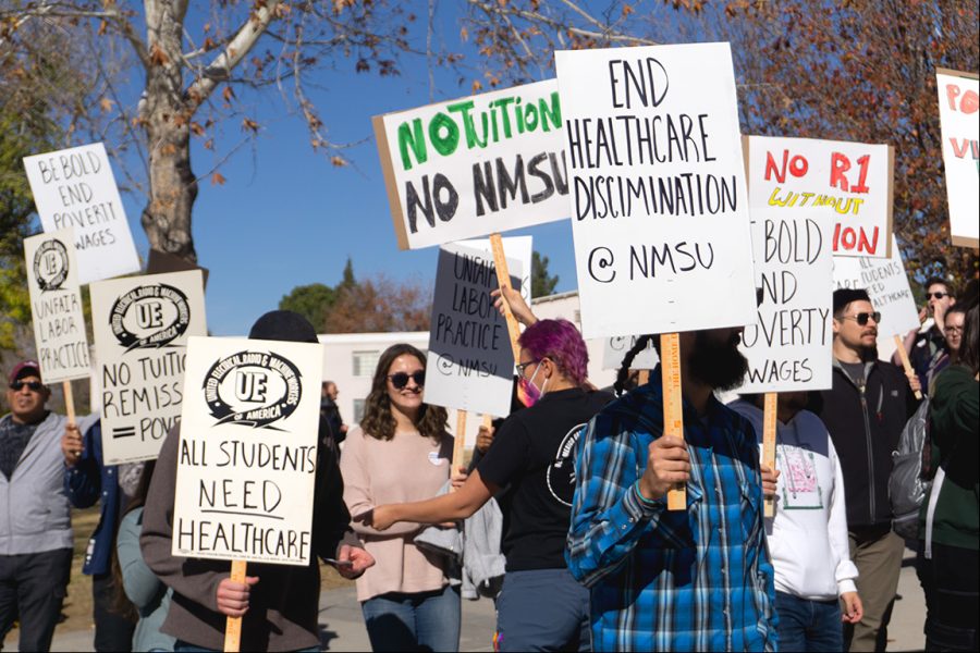 Graduate+students+and+community+members+carried+signs+while+circling+outside+Corbett+Center+Student+Union+on+on+Dec.+1%2C+2022%2C+calling+on+NMSU+administration+to+negotiate+their+needs.+
