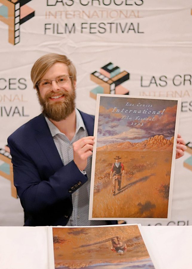 Rush Allen, local artist, holds the official poster for the upcoming Las Cruces International Film Festival. 