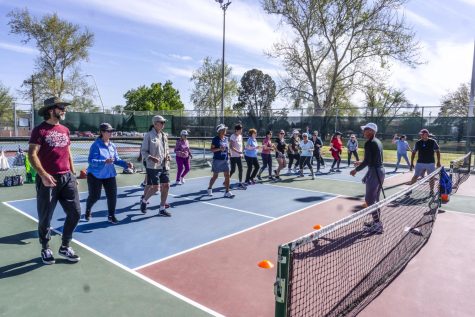 John Allevi, a pickleball trainer, coaches the group of players through some warm up routines on April 6, 2023, at Apodaca Park. 