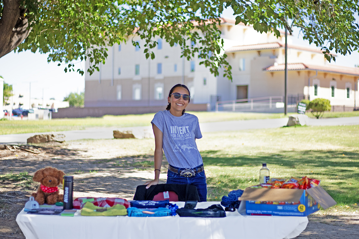 Founder of For Students By Students Kiara Schroeder poses in front of the merchandise being sold during their on campus flea market on Sept. 4, 2023.