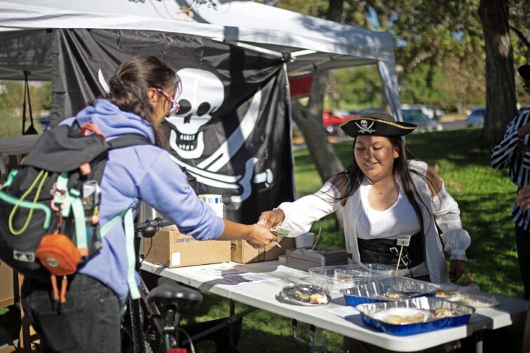 Quiz Bowl team member selling pastries to a NMSU student. 