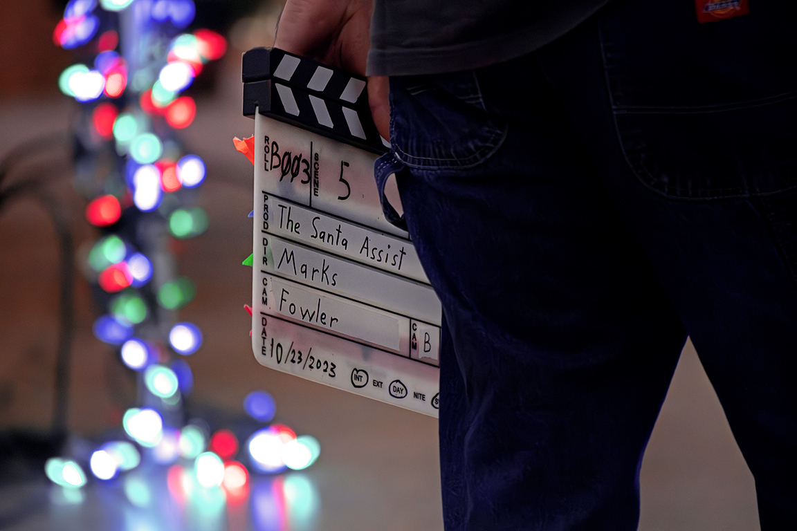 A crew member holding a clapperboard on the set of “The Santa Assist” on Oct. 23, 2023. The filming of this movie allows NMSU Creative Media Institute students to gain job experience working on a real film production. 
