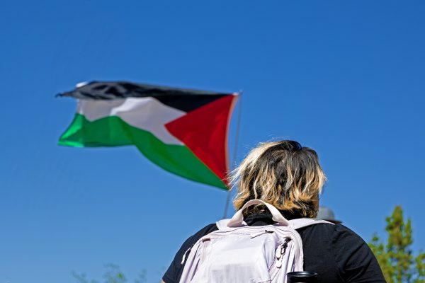 Protestor walks by a waving Palestinian flag. April 29, 2024.