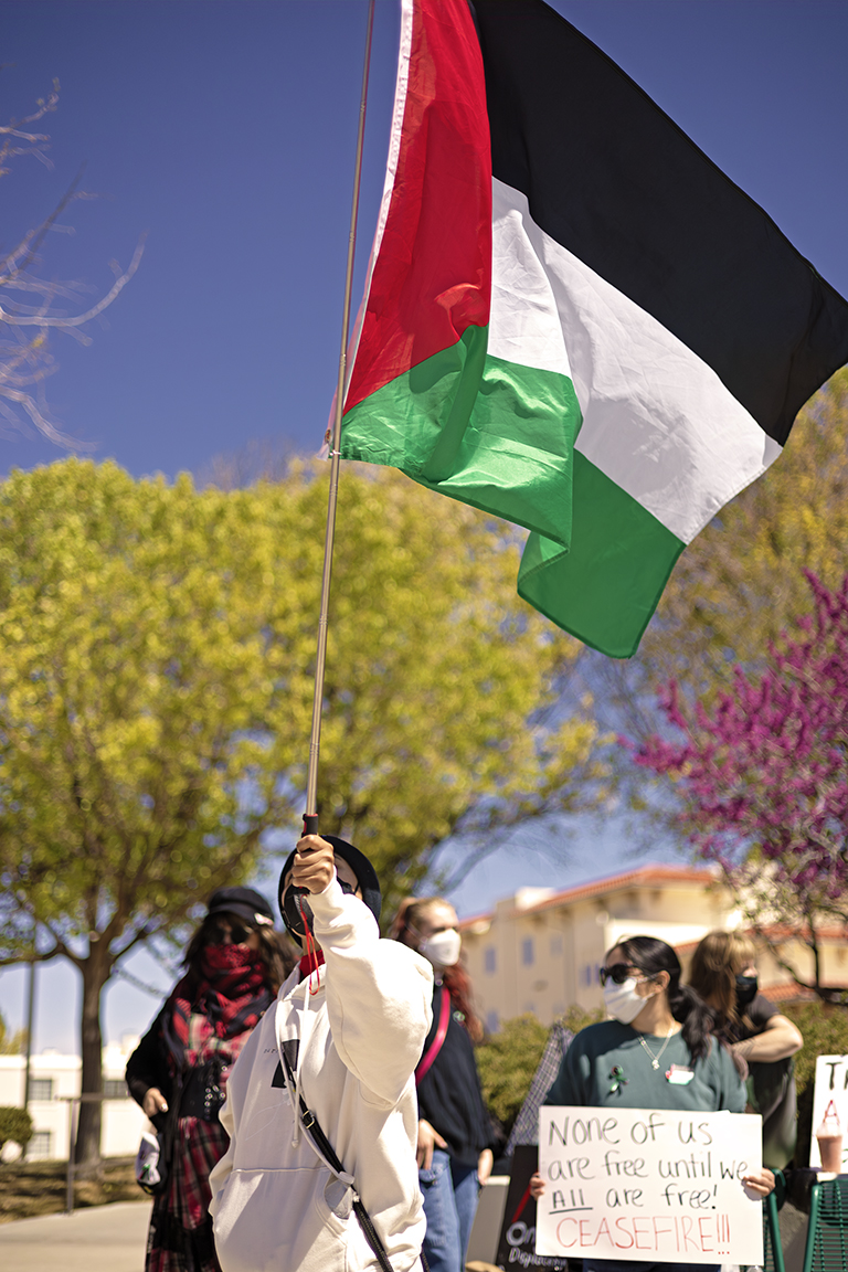 A protestor waves a Palestinian flag in front of Corbett Center Student Union. March 28, 2024.
