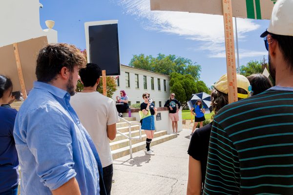 Protesters stand outside Hadley Hall and listen to announcements from one of the organizers.