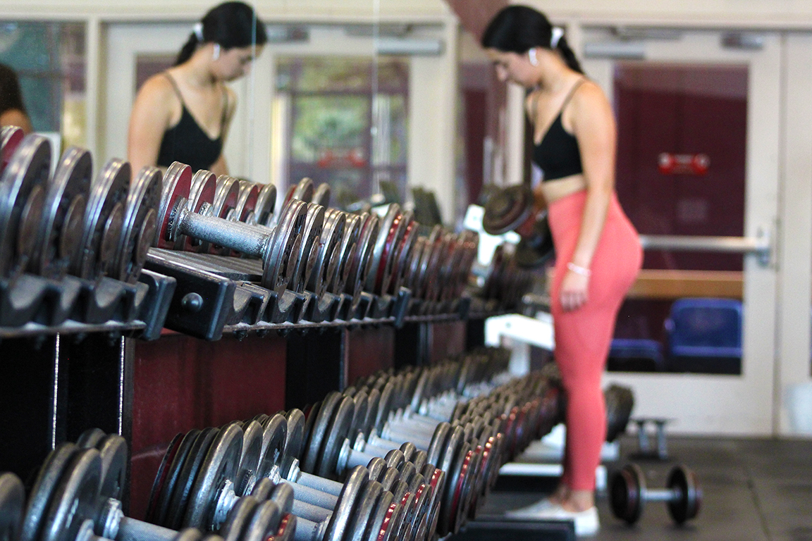 An NMSU student reracks her weights in the James B. Delamater Activity Center’s weight room. Sept. 11, 2024.  