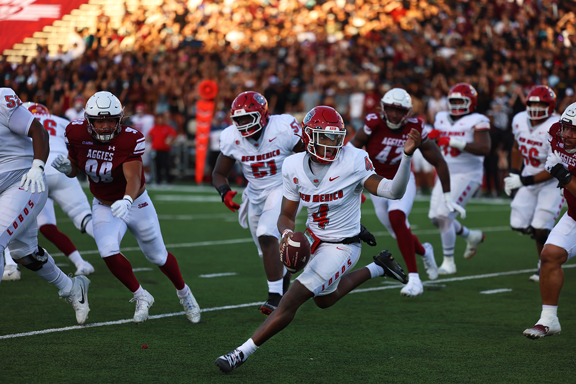 University of New Mexico's quarterback Devon Dampier avoids the New Mexico State defense in the Battle of I-25 on Saturday, Sept. 28, 2024, at Aggie Memorial Stadium. 