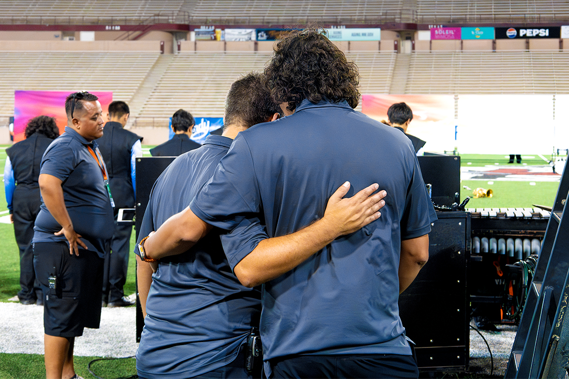 Associate Band Directors at Del Valle High School, Robert Hayden (left) and Jonathan Reyes (right) share a hug leading to their final performance. Sept. 21, 2024.