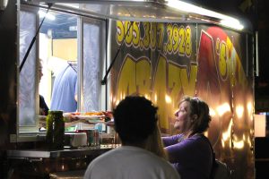 A woman buys pizza from Crazy D’s food truck at the 2024 Pizza Festival. Oct. 11, 2024.