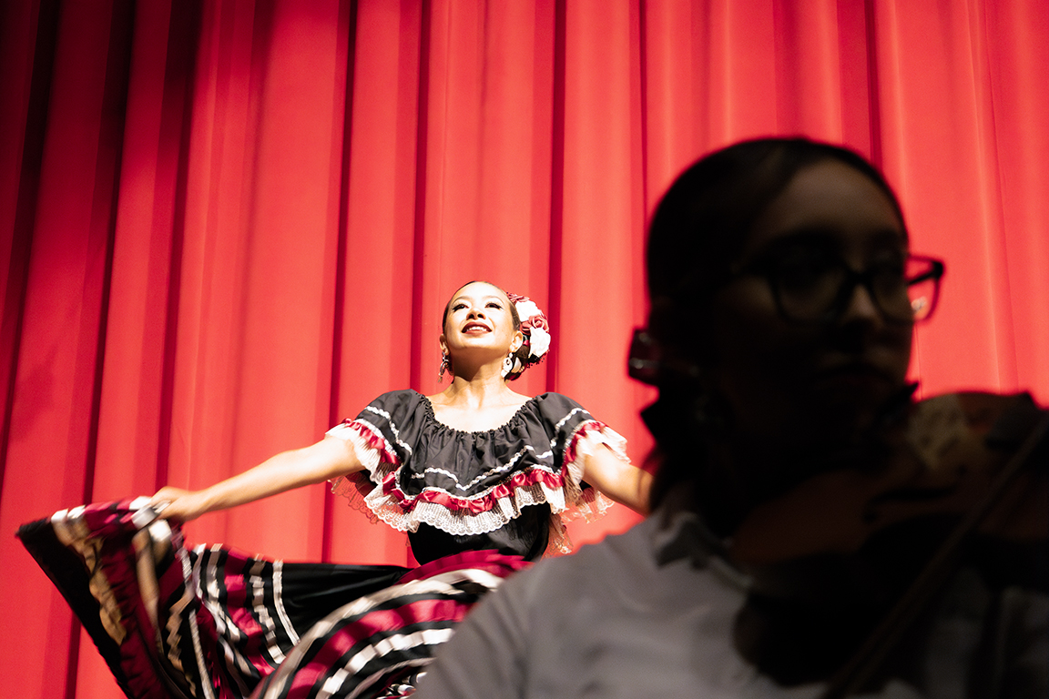 A NMSU Folklorico dancer is lit up by the Atkinson Recital Hall stage lights. Sept. 22, 2024. 