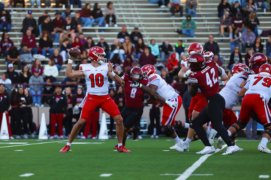 Western Kentucky’s quarterback, Caden Veltkamp, throws the ball against oncoming New Mexico State defense in Aggie Memorial Stadium. Nov. 9, 2024 