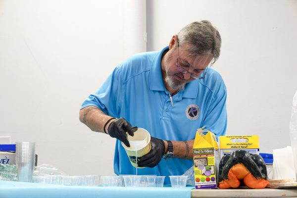 Brandon Green, Materials and Applications Specialist at Reynolds Advanced Materials, pours chemicals in small cups for each participant to create their own mold. Nov. 12, 2024. 