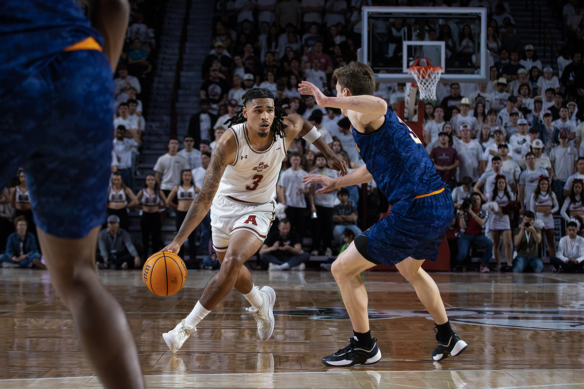 NMSU Aggie Christian Cook avoids UTEP Miner Baylor Hebb in the Battle of I-10 at the Pan American Center. Feb 8, 2025