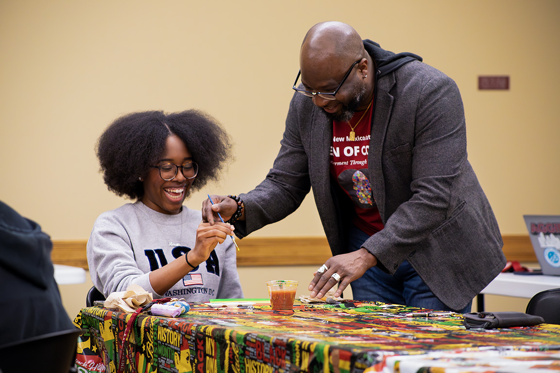 Advisor Patrick Turner helps Aaliyah Walker with her painting at the Sip N' Paint event, hosted by NMSU’s Men of Color Initiative, Black Programs, and Latin American Programs. Jan 30, 2025.