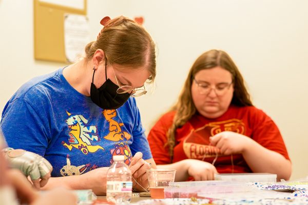 Two students make their bracelets using beads and string. Feb. 13, 2025. 