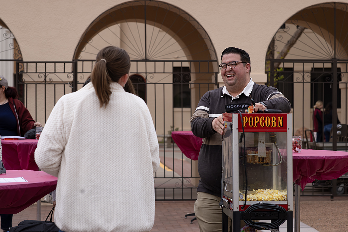 Journalism and Media Studies program specialist Kyle Ivy laughs with some of the event organizers. April 3, 2025. 