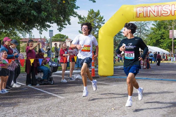 Two boys race each other to the finish line during the Gratitude Run on Saturday, September 13, 2025.