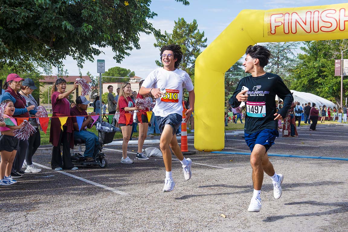 Two boys race each other to the finish line during the Gratitude Run on Saturday, September 13, 2025.