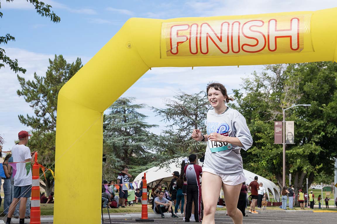 A participant smiles as she crosses the finish line during the 5K Gratitude Run event on September 13, 2025.
