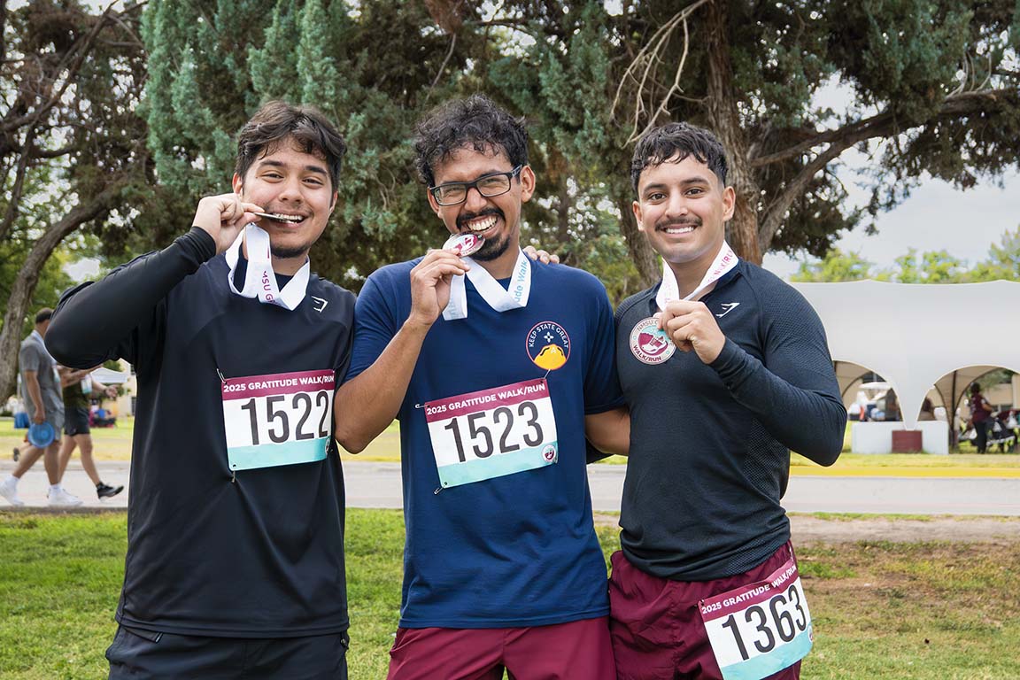 Three friends pose with their medals after completing the Gratitude Run on September 13, 2025.