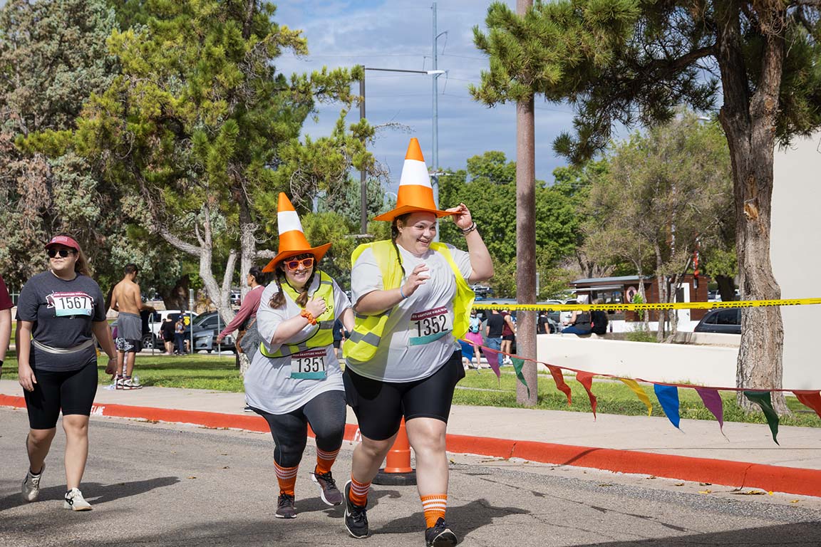 Runners in traffic cone costumes bring color and fun to the 5K Gratitude Run on September 13, 2025.