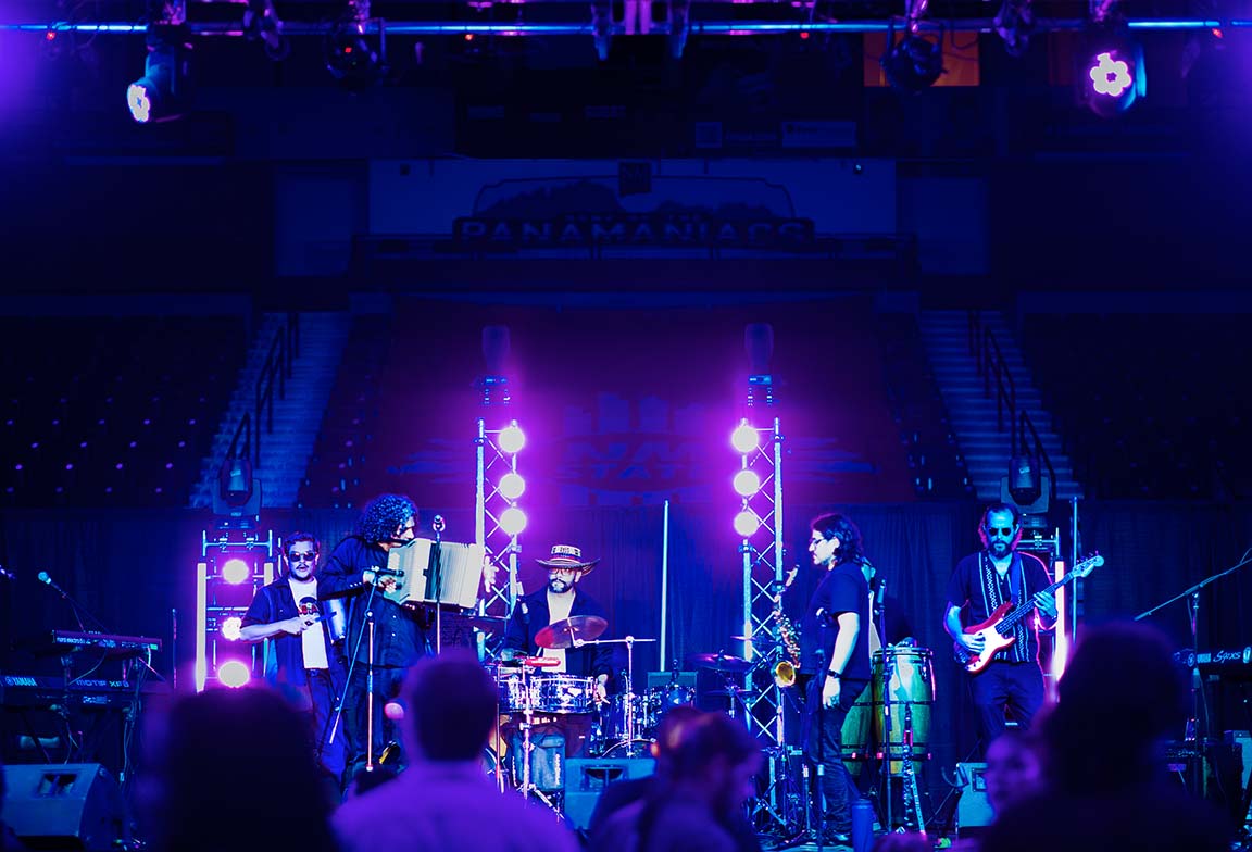 Frontera Bugalú playing cumbia rhythms under vibrant stage lights at the Pan American Center, Sept. 18, 2025. 