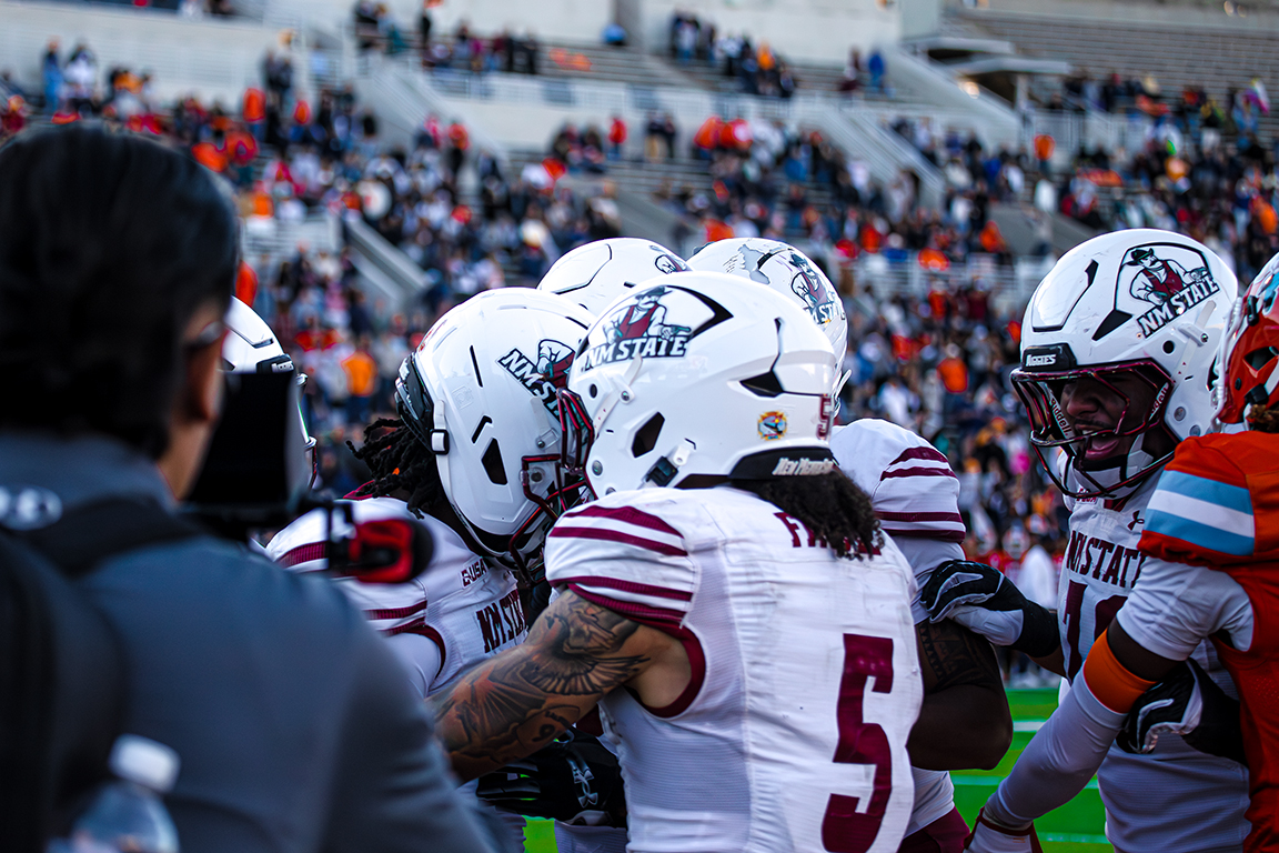 The NMSU Aggies all gather around TK King (left) after he scored the winning touchdown. Nov. 22, 2025. 