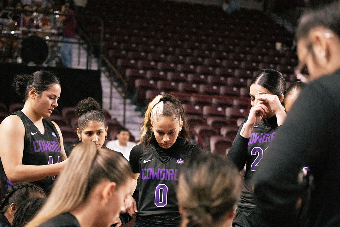 Opponent No. 0, Jaelyn Bates, listens to her coach during a timeout huddle.