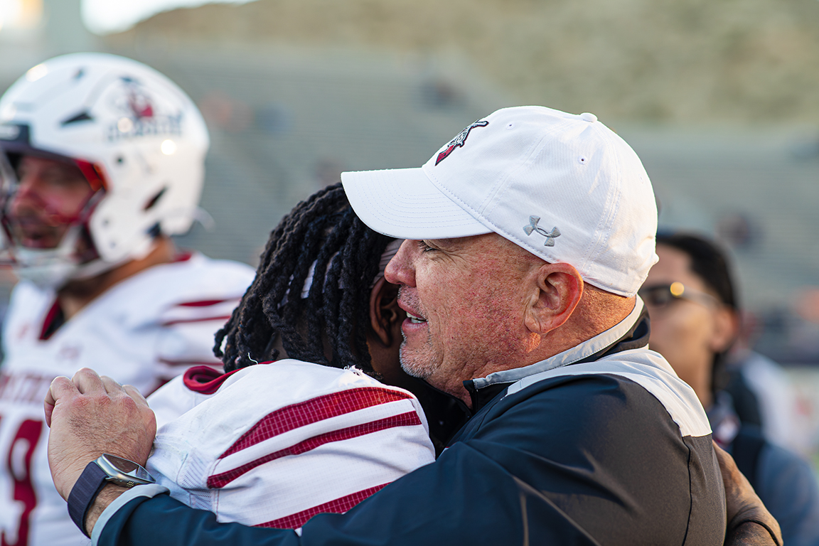 Head coach Tony Sanchez hugs TK King after the Aggies won. Nov. 22, 2025. 