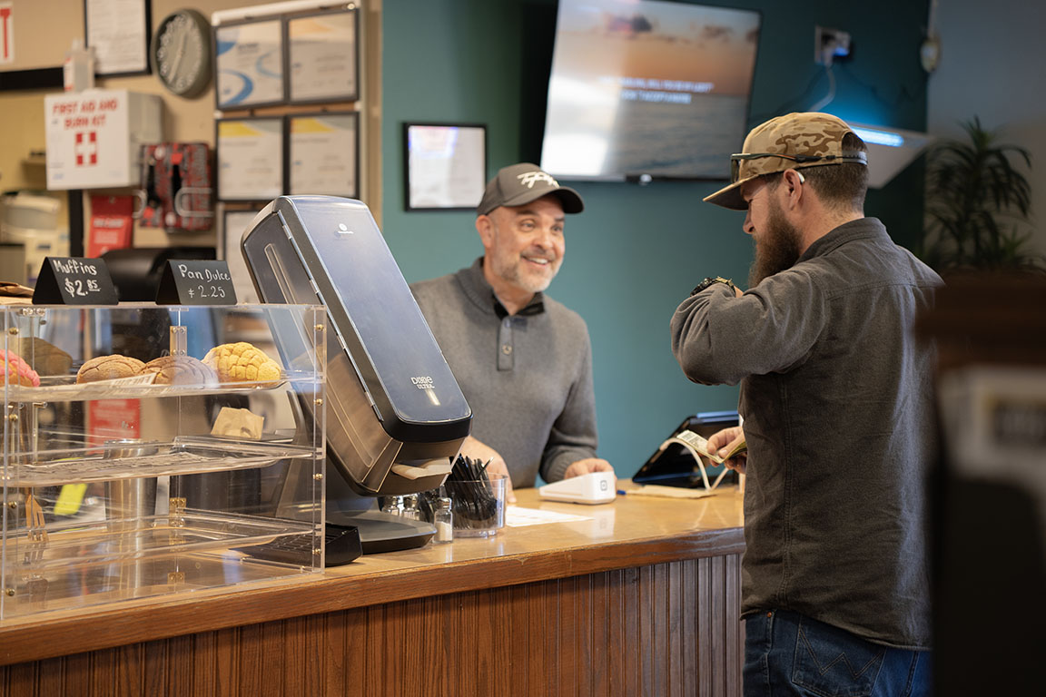 A moment of laughter between a cashier and customer highlights the welcoming atmosphere at La Jefa 