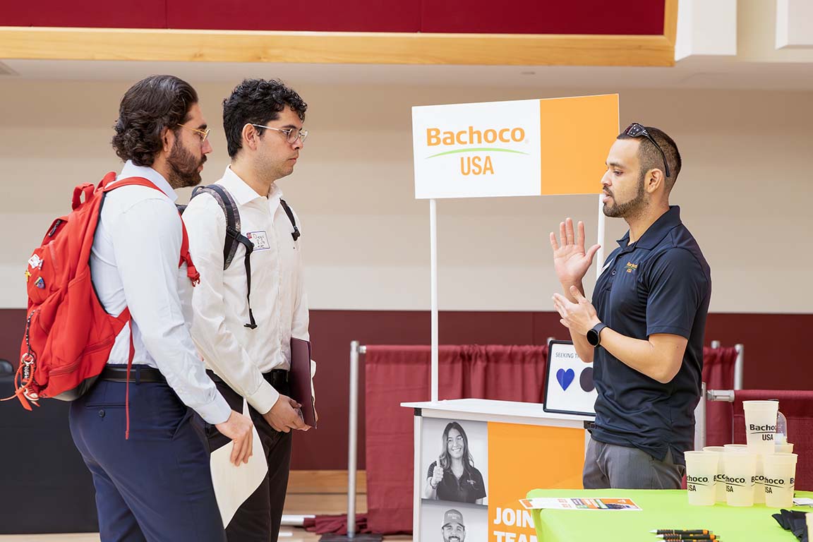 A representative from Bachoco USA speaks with students about job opportunities at the Aggie Career Fair on Feb. 3, 2025.