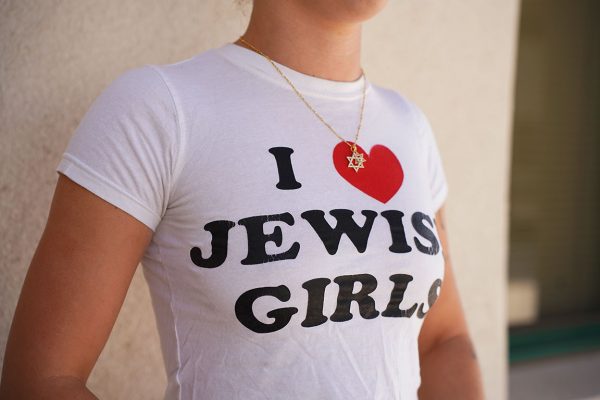 Bodhi Fogden poses wearing a Star of David necklace and a shirt reading “I heart Jewish Girls” for an opinion feature on navigating Jewish identity in todays political climate.