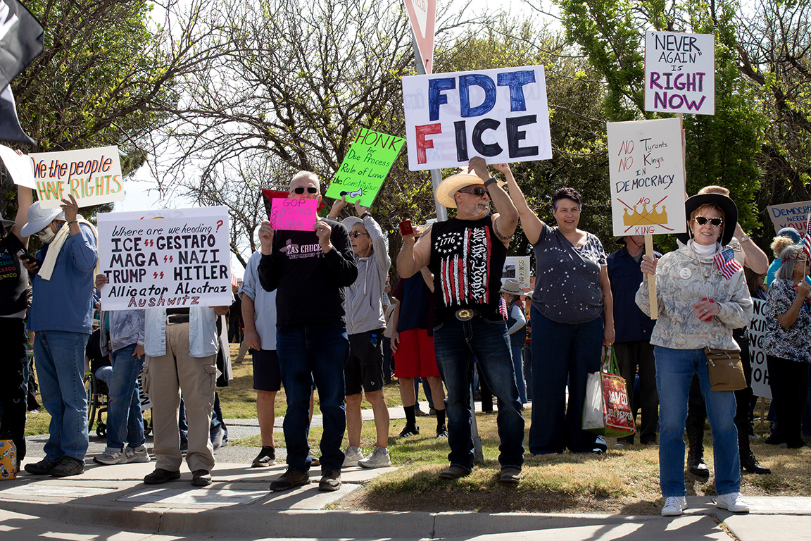 Dozens of protestors stand on N. Main Street and Picacho Avenue with signs that read "Where are we heading? ICE=Gestapo Maga=Nazi Trump=Hitler Alligator Alcatraz Aushwitz" and "FDT F ICE." March 28, 2026.