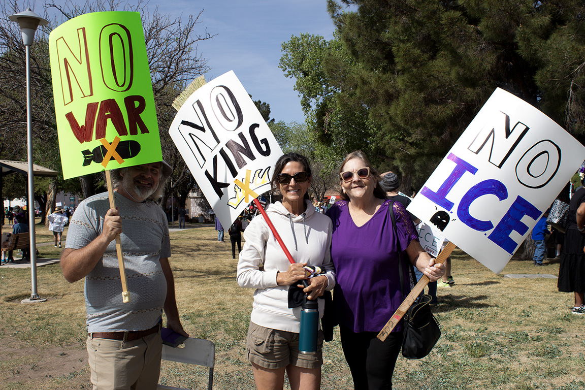 Three protesters carry signs that read "No War," "No King" and "No I.C.E." March 28, 2026.
