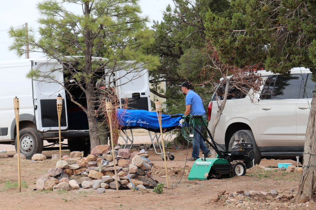 Workers remove a body in Mountainair, N.M., Wednesday, May 20, 2026, after several people died and more than a dozen first responders were exposed to an unknown substance. 