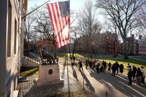 People take photos near a John Harvard statue, left, on the Harvard University campus, Jan. 2, 2024, in Cambridge, Mass. (AP Photo/Steven Senne)