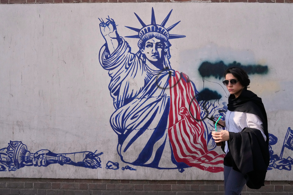 A woman walks past an anti-American mural on the wall of the former U.S. Embassy, now a museum, in Tehran, Iran, Friday, June 12, 2026. (AP Photo/Vahid Salemi)