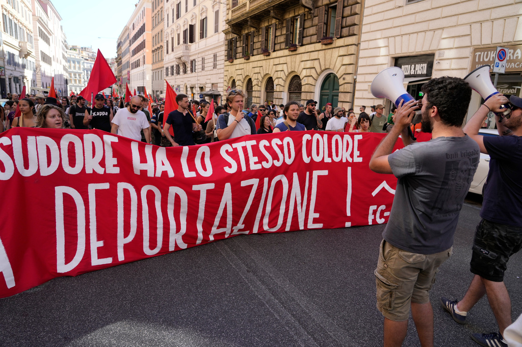 Varias personas portan una pancarta en italiano con el lema "La piel y el sudor tienen el mismo color, no a la deportación" durante una marcha en Roma, el sábado 13 de junio de 2026, para protestar contra el paquete de medidas de seguridad y migración de Italia, que incluye un plan de "bonificación por repatriación" para migrantes. (Foto AP/Gregorio Borgia)