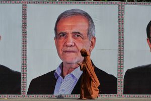A woman walks past a welcoming billboard featuring Iranian President Masoud Pezeshkian along a roadside in Islamabad, Pakistan, Tuesday, June 23, 2026. (AP Photo/Anjum Naveed)